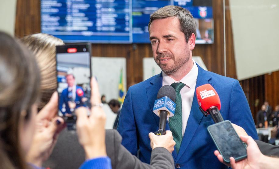 O Defensor Público Geral fala para a imprensa, cercado por microfones, câmaras e celulares.