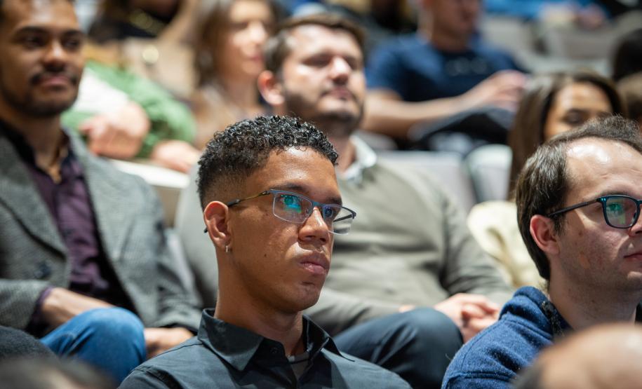 Foto em detelhe em que se vê os novos servidores sentados no auditório acompanhando discursos de posse.