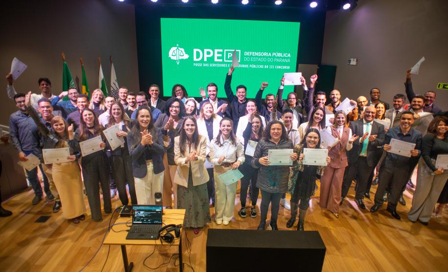 Servidores posam juntos no placo para foto ao fim da cerimônia.