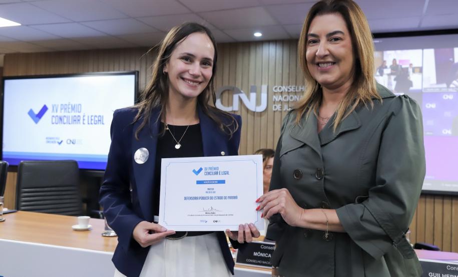 A Primeira Sub-Defensora Geral do Estado Livia recebe congratulações de uma representante do Conselho Nacional de Justiça.