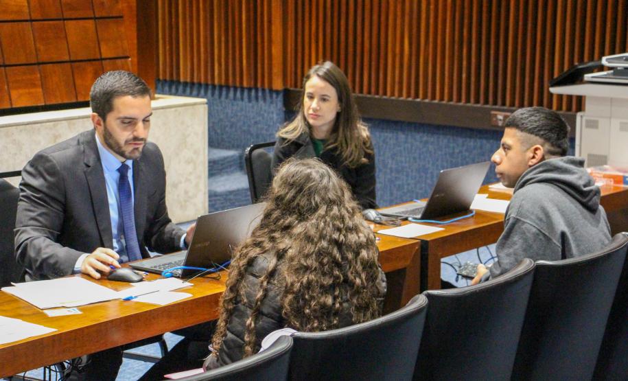 Defensor Público e servidora atendem casal assistido pela DPE-PR em mutirão no Plenarinho da ALEP.