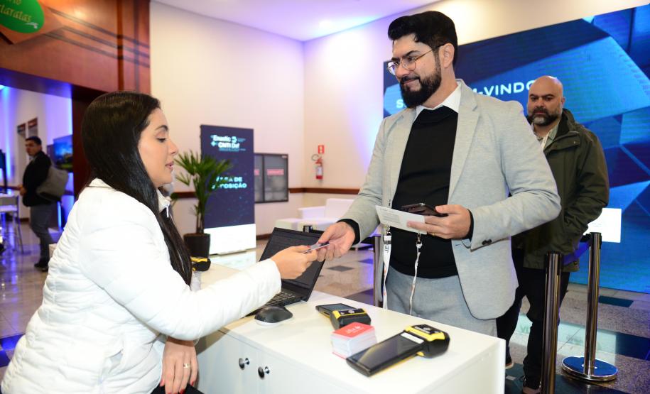 Mulher sentada apresenta serviços de tecnologia para homem com barba de terno em pé.