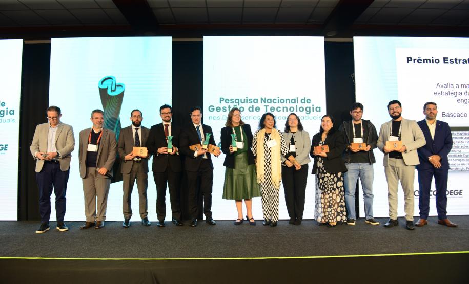 Imagem mostra os vencedores da Pesquisa Nacional de Transformação Digital e Gestão de Tecnologia nas Defensorias Públicas Estaduais posando no palco do Enastic, evento realizado em Foz do Iguaçu.
