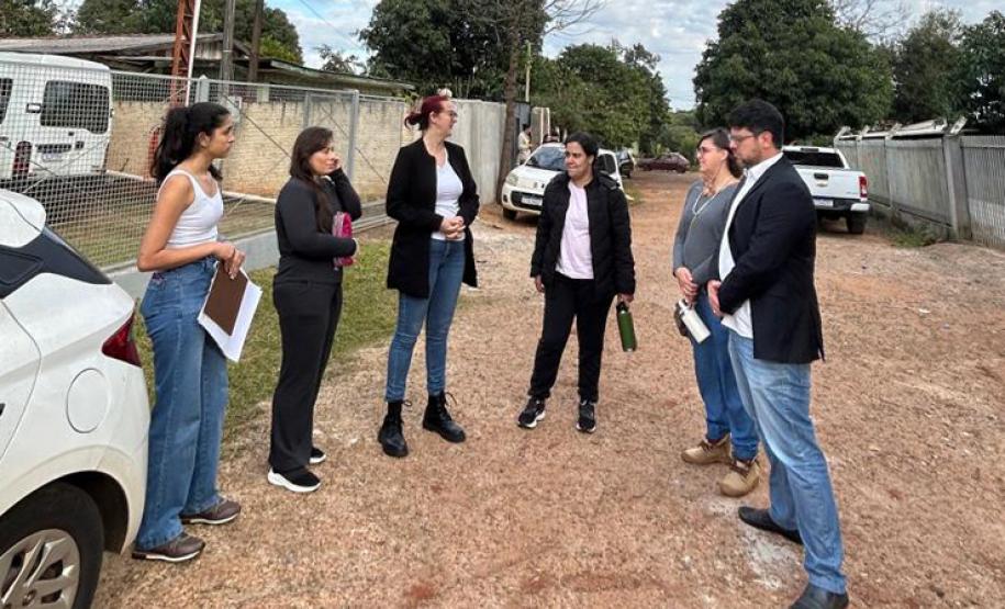 Equipe do NUFURB discute estratégias antes da atuação no território. Seis pessoas conversam em uma rua de barro.