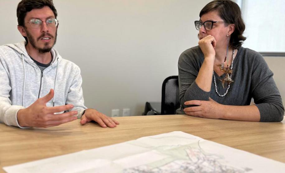 Equipe do NUFURB discute estratégias de atuação. Sobre a mesa se vê um mapa da comunidade.