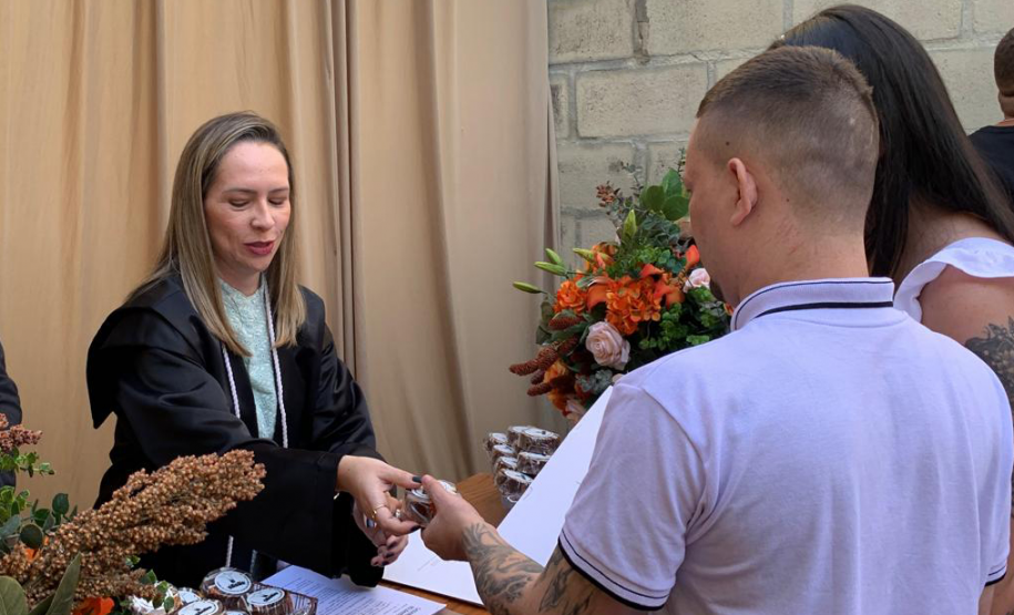 Imagem mostra Juíza de Paz celebrando casamento. O casal aparece de costas.