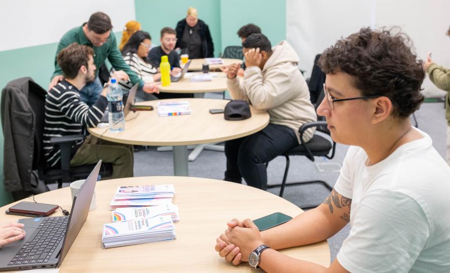 Em primeiro plano um assistido da DPE-PR recebe orientação jurídica sobre retificação de nome nos documentos.