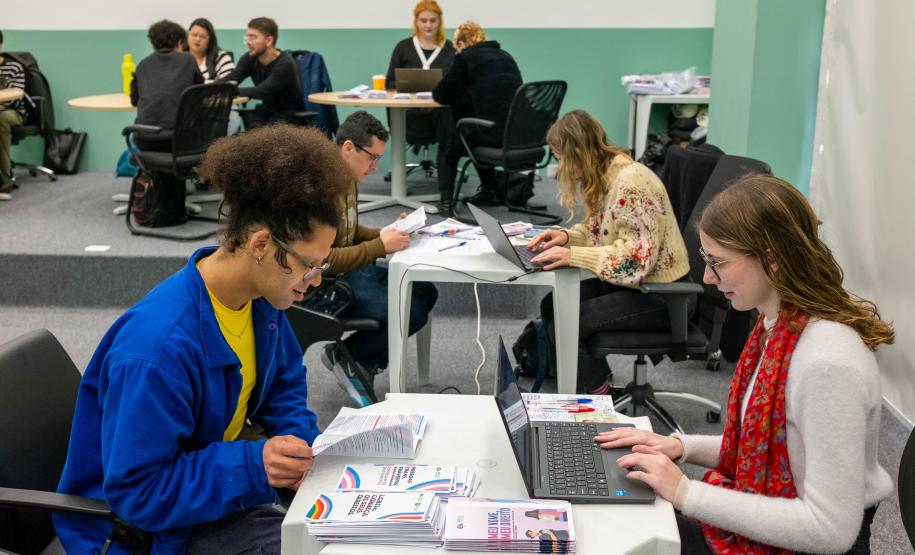 Em primeiro plano um assistido recebe atendimento da DPE-PR em Mutirão Meu Nome Meu Direito.