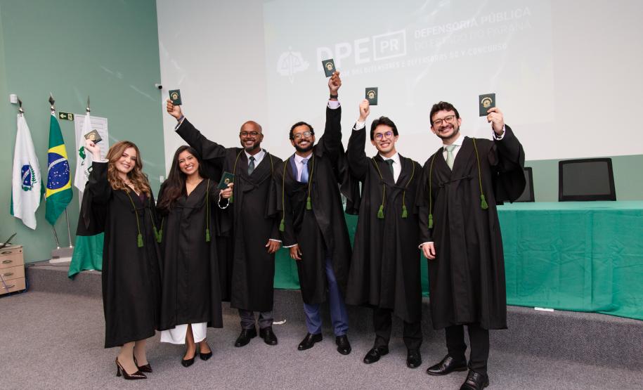 Novos defensores públicos posam com suas carteiras funcionais ao final da cerimônia de posse.