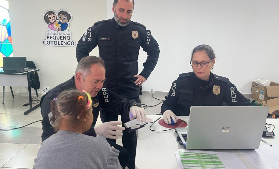 Servidores do Instituto de Identificação realizam a coleta de digitais para realização da identidade de uma mulher idosa que reside no Pequeno Cotolengo.