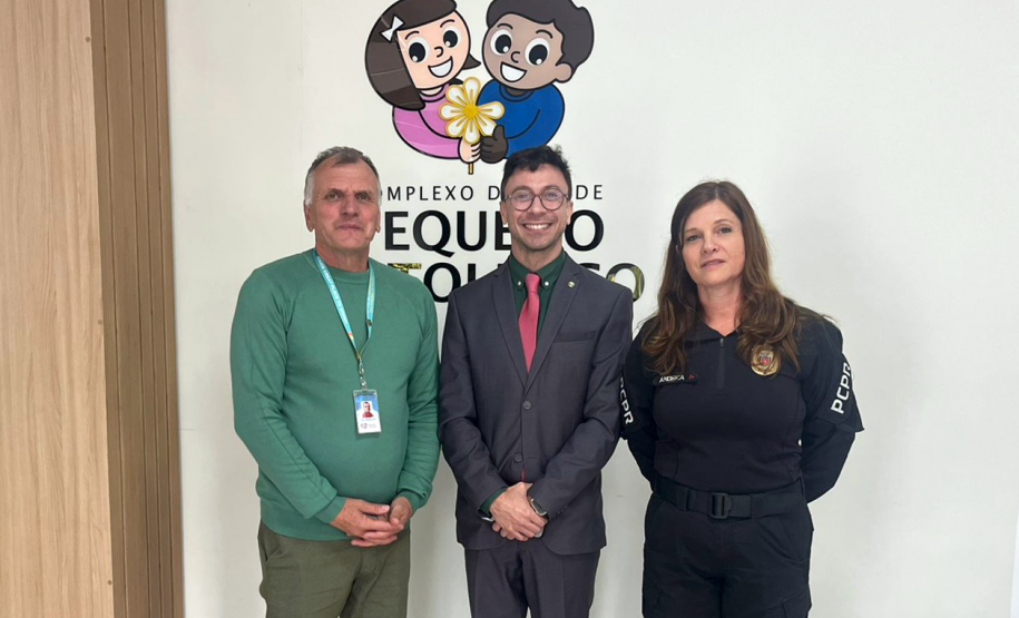 Autoridades posam em frente a logo do Pequeno Cotolengo após a ação.