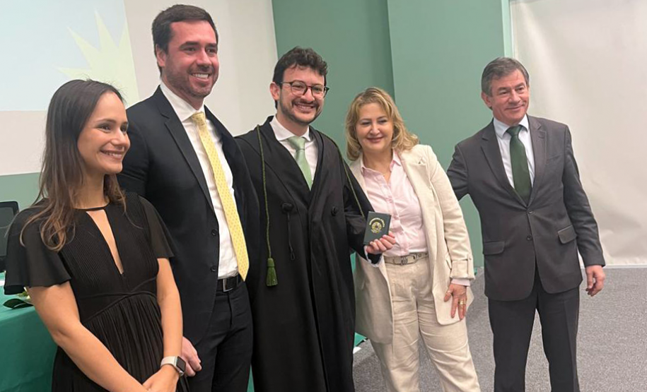 Novo defensor público empossado posa ao lado de representantes da instituição e familiares.