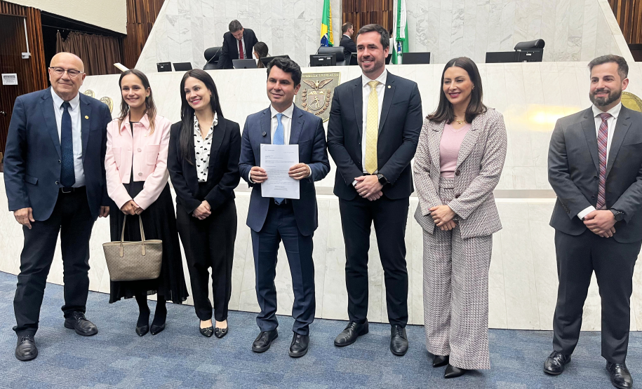 Imagem com a foto de representantes da Defensoria na Assembléia Legislativa do Paraná, junto do deputado Alezandre Curi, para entrega de projeto de Lei