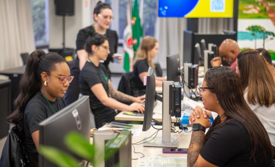 Imagem mostra servidores da Defensoria Pública atendendo a população.