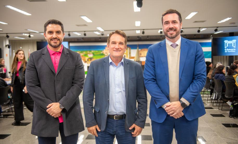 Três homens de terno posam para imagem durante o Mutirão.