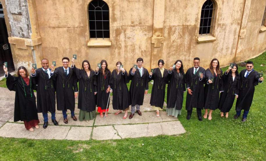 Novos defensores públicos empossados hoje posam com suas becas e carteirtas funcionais em frente ao Teatro Paiol.
