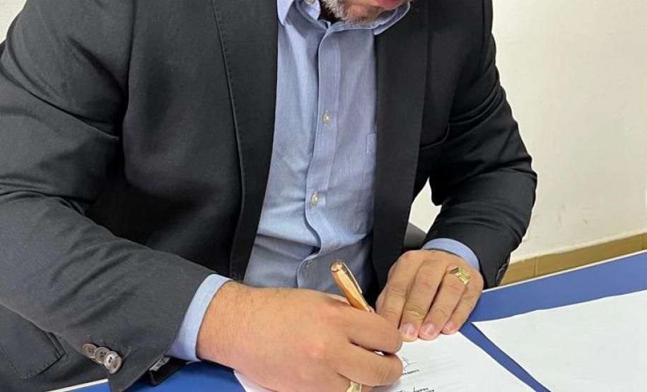 O Defensor Público João Victor Rozatti Longhi assina documento de aluguel social em Faxinal.