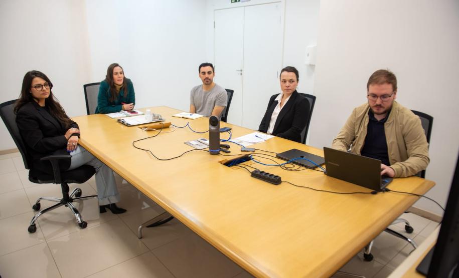 Equipe da captação de recursos sentados a uma mesa de reuniões.