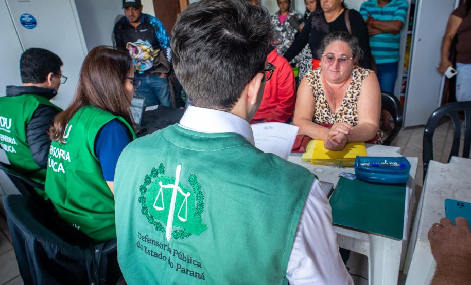 Defensor Público aparece de costas realizando atendimento para uma mulher em Guaraqueçaba.