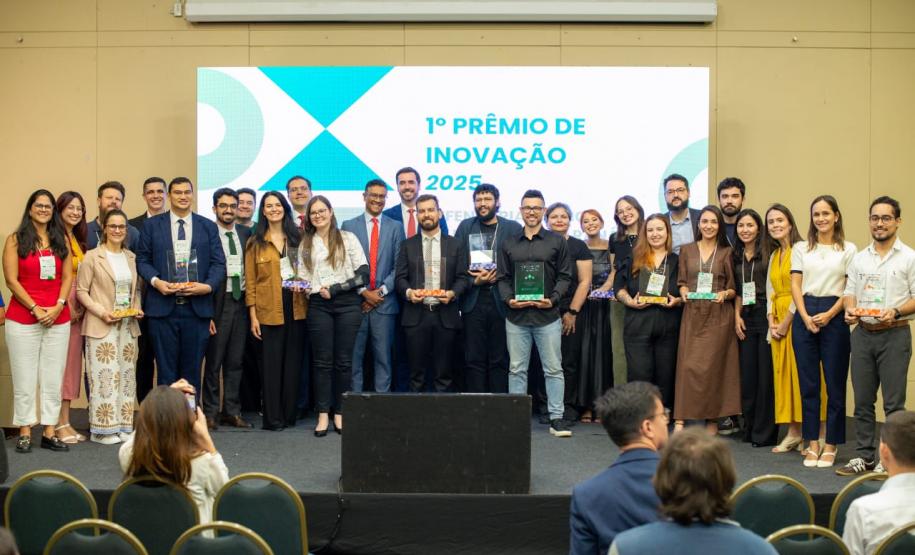 Premiados no concurso de inovação da Defensoria posam para foto no palco do evento.