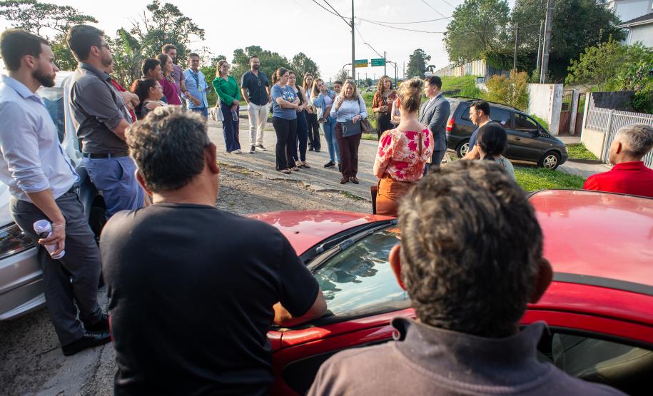 Imagem mostra várias pessoas em circulo no centro da comunidade em reunião com autoridades do poder judiciário.