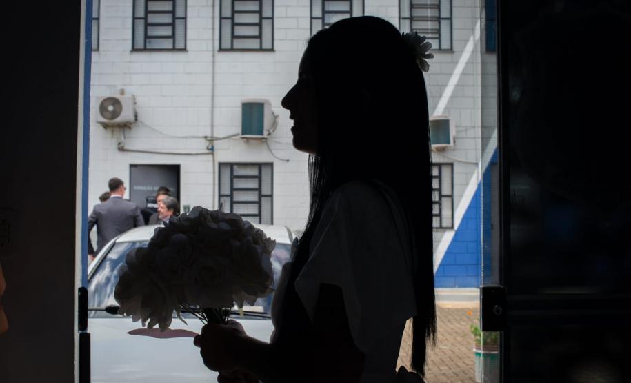 Silhueta de uma das noivas que se casou no projeto Casando Diretos. Ao fundo a Penitenciária de Francisco Beltrão.