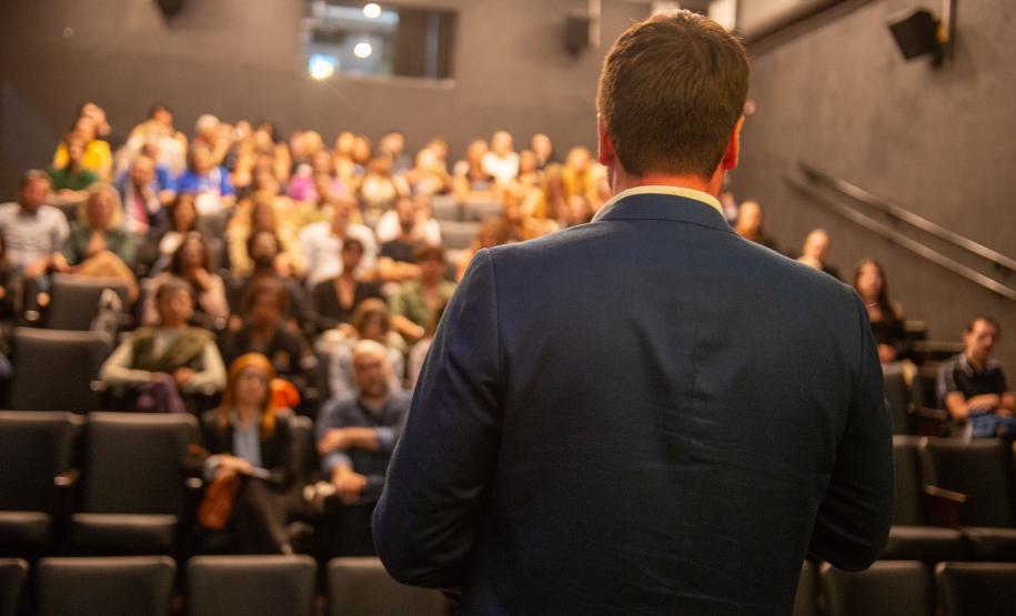 Público acompanha fala antes do início da apresentação.