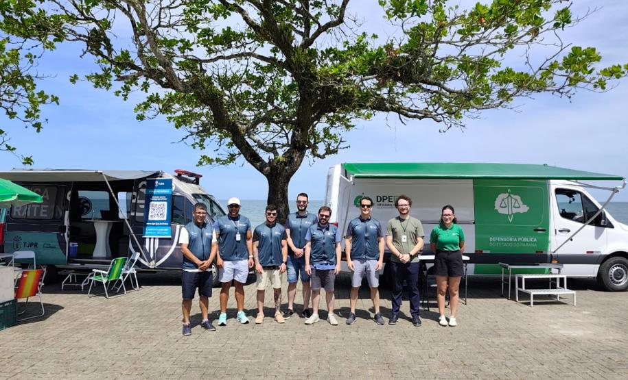 Equipe da Defensoria Pública do Paraná posa em frente à Van de Direitos durante a Operação Verão Maior em Matinhos.