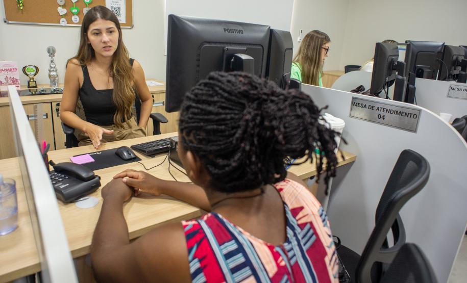 Imagem mostra mulher negra de costas sendo atendida em sede da DPE-PR em Paranavaí, no interior do estado.