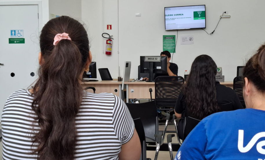 Imagem mostra duas mulher de costas aguardando na fila para recebem atendimento durante o Mutirão da Defensoria em Maringá.