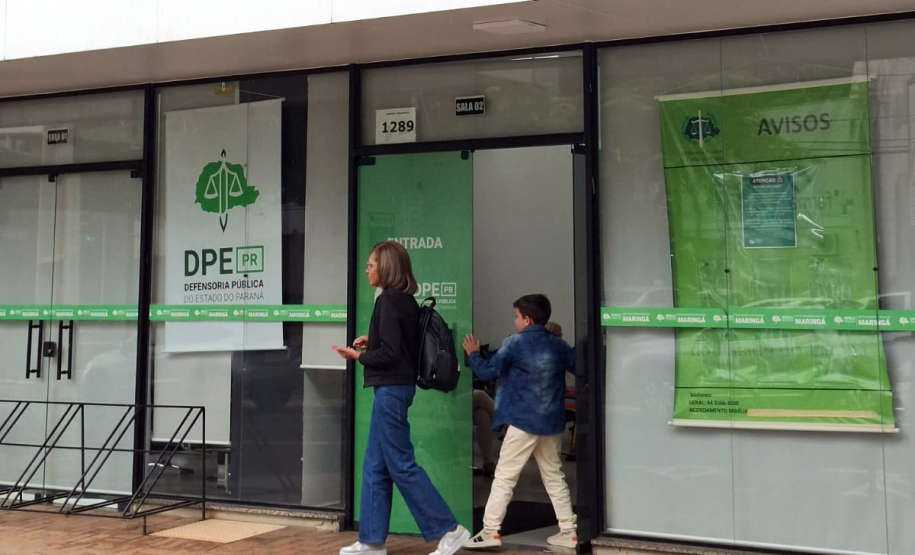 Mulher e criança vistos de longe chegam à sede da DPE-PR em Maringá para participar de Mutirão;