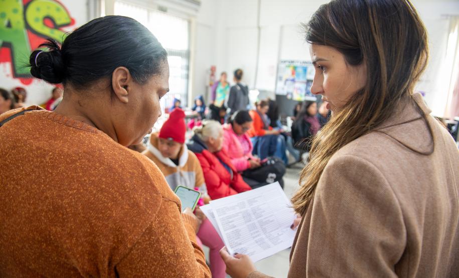 Imagem mostra Defensora Pública conversando com uma assistida durante mutirão de atendimentos da DPE-PR.