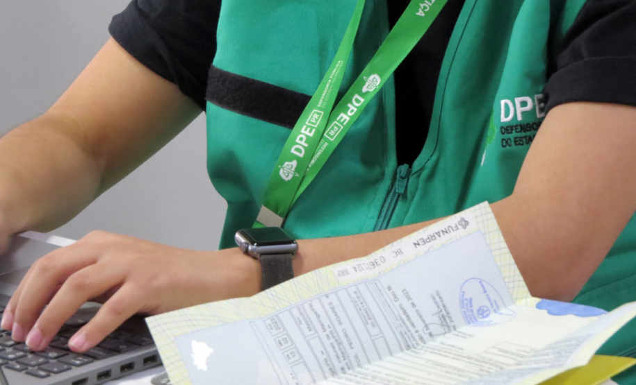 Imagem mostra detalhe de servidora com colete da DPE-PR.