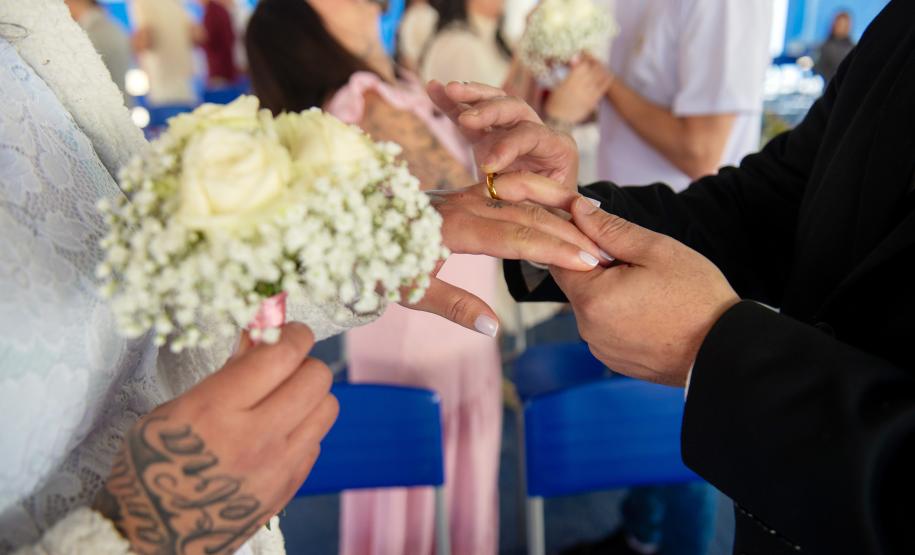 Imagem mostra detalhe de homem colocando aliança do dedo de uma mulher durante a cerimônia do projeto Casando Direitos.