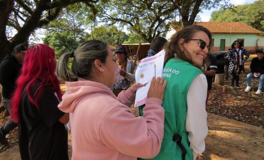 Indígena assina protocolo nas costas de Defensora Pública.