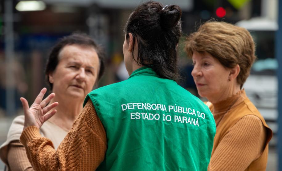 Psicóloga da Defensoria Pública conversa com senhoras idosas em trabalho de orientação na Boca Maldita, em Curitiba.