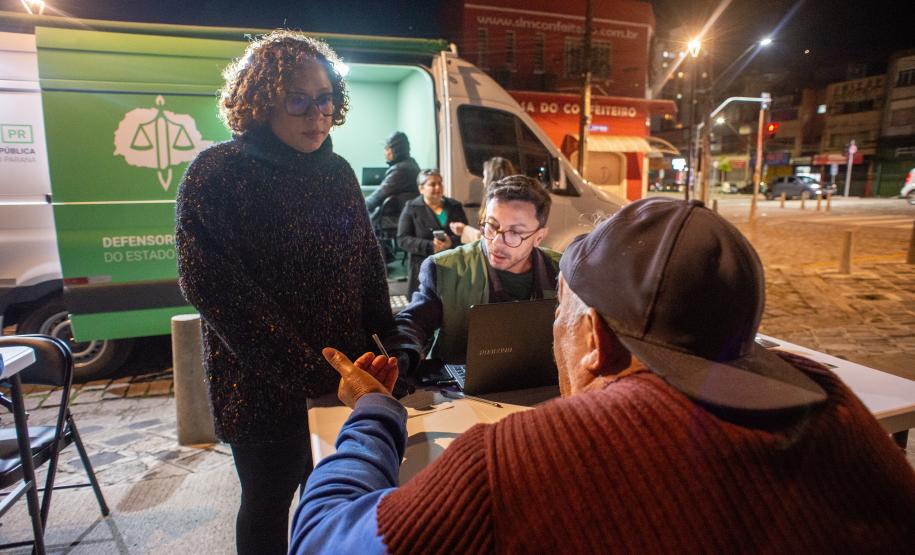Imagem mostrar atendimento à população em situação de rua à noite.