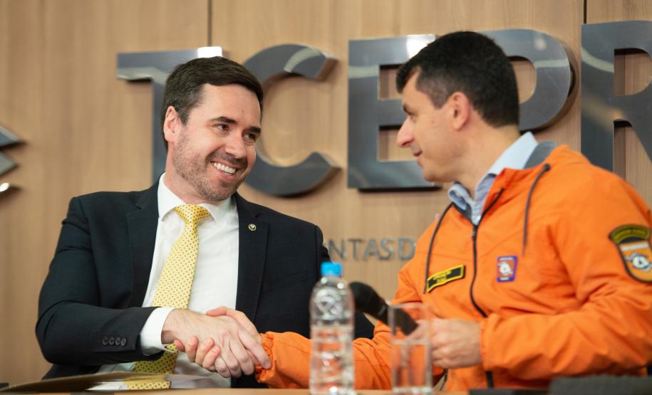 Chefe da Defesa Civil cumprimenta o DPG Matheus Munhoz.