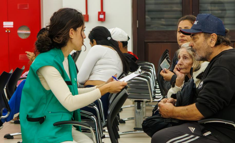 Imagem mostra servidora da DPE-PR realizando atendimento de família durante Mutirão Meu pai Tem Nome.