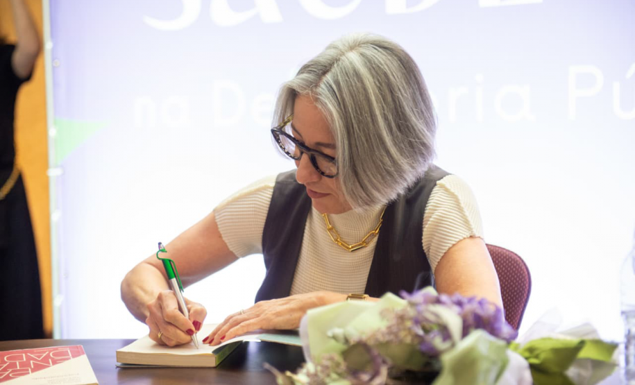 Palestrante autografa livro.