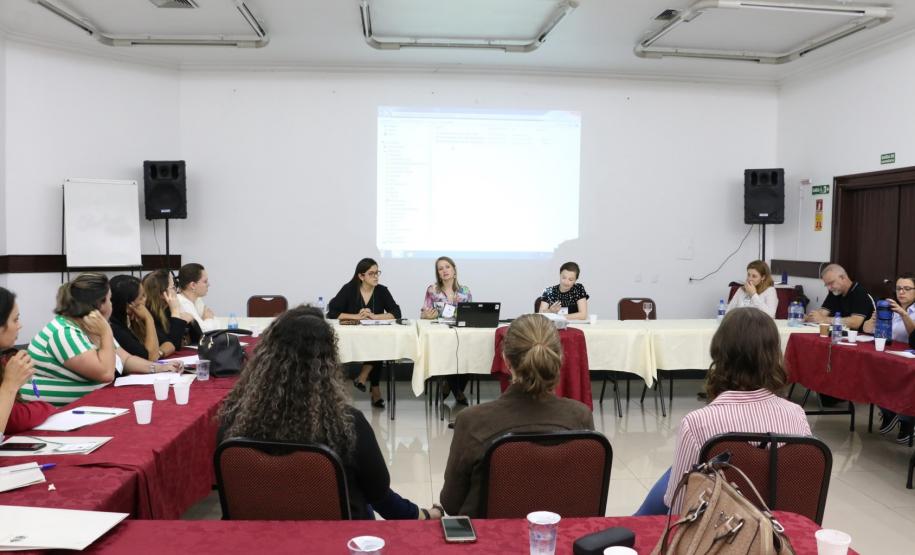 Na imagem vemos  os Assistentes Sociais participantes do evento sentados em mesas distribuídas em forma de roda, debatendo.