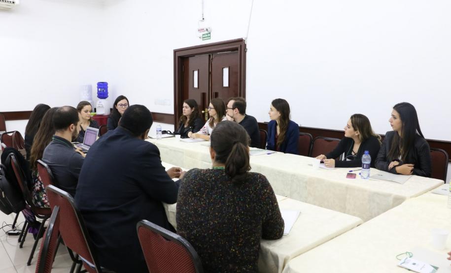 Na imagem vemos os Psicólogos participantes do evento sentados em mesas distribuídas em forma de roda, debatendo.