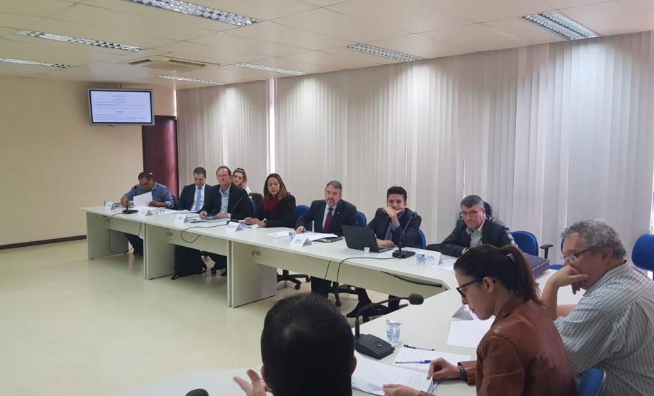 Mesa da Comissão de Mediação de Conflitos Fundiários do Governo do Estado com os representantes sentados em sua volta.