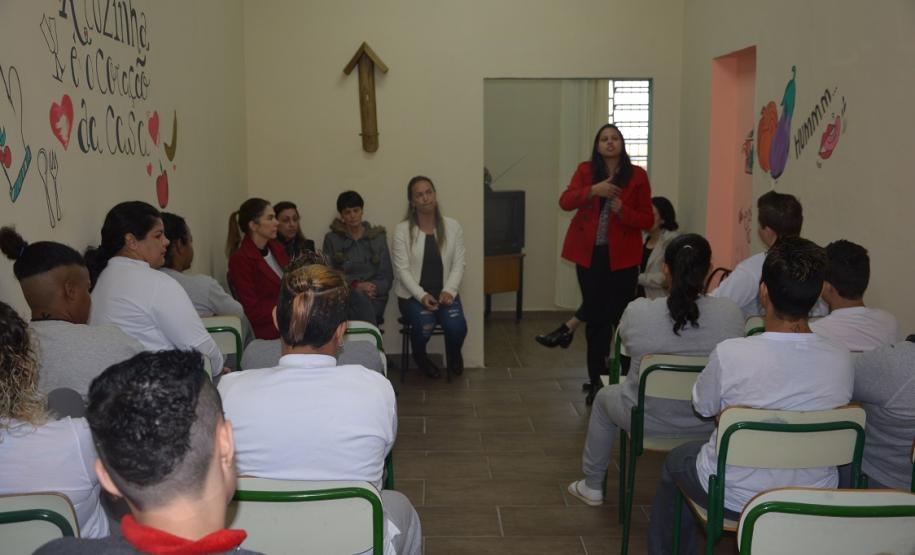 Dra. Cinthia Azevedo Santos está palestrando, no fundo de uma sala, na penitenciária feminina.