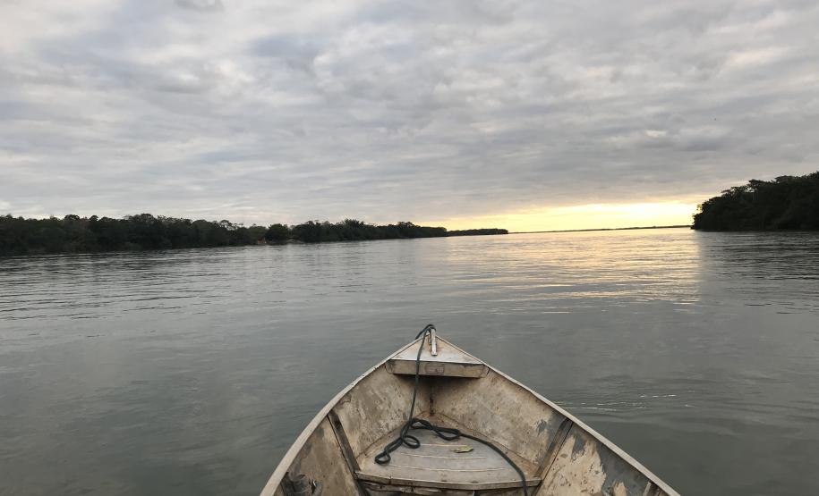 NUCIDH e NUPOVOS realizaram a 4ª Etapa do curso de Direitos Étnicos e Coletivos para os Ilhéus do Rio Paraná nas cidades de Umuarama e Querência do Norte A foto foi tirada dentro de um barco simples de pescador. Vemos a parte frontal do barco, seu bico, o barco está no rio e ao fundo vê-se o pôr do sol.
