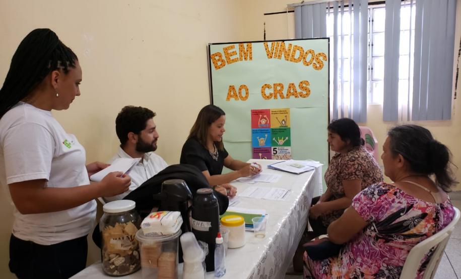 Na imagem vemos alguns defensores públicos sentados a uma mesa conversando com assistidos.