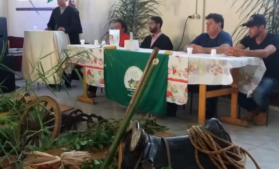 Mesa dos formadores ao fundo, na frente vegetações e símbolos faxinalenses.