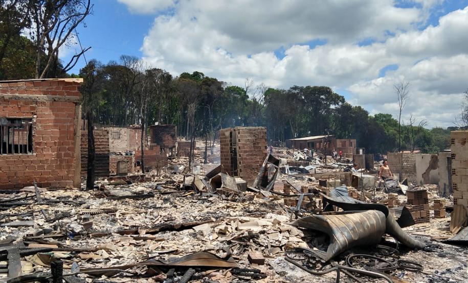 Foto mais ampla mostrando o que restou das estruturas pós incidente. Vemos muitos escombros e algumas paredes de tijolos ainda de pé.