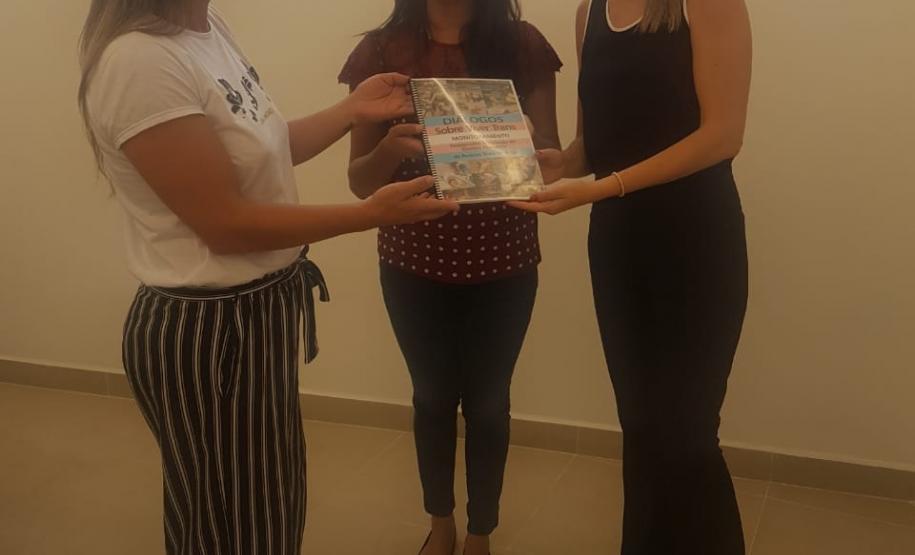 NUDEM e NUCIDH recebem documento sobre Monitoramento de Assassinatos e Violação de Direitos Humanos de Pessoas Trans no Brasil. Na imagem vemos as Dras. Coordenadoras Eliana Tavares Paes Lopes e Cinthia Azevedo Santos e a presidente do Transgrupo Marcela Prado. Karollyne Nascimento segurando o documento “Diálogos Sobre Viver Trans - Monitoramento de Assassinatos e Violação de Direitos Humanos de Pessoas Trans no Brasil”.
