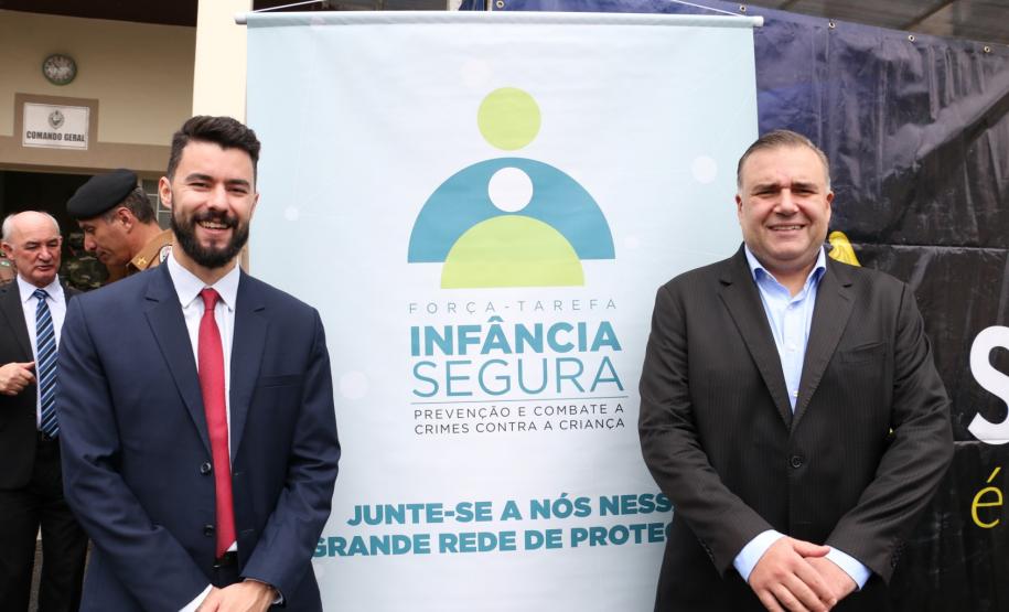 Na esquerda, o subdefensor público-geral, dr. Rodolpho Mussel de Macedo. Na direita, o secretário da Justiça, Família e Trabalho, Ney Leprevost. No meio, o cartaz da força-tarefa.